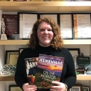 Appalachian alumnus Glenn Ramey ’19 at the Explore Asheville Convention and Visitors Bureau, where she works as a group sales and service specialist. Ramey, who is pictured holding two visitor guides published by the bureau, graduated summa cum laude from Appalachian in 2019 with a B.A. in theatre arts and minors in general business and nonprofit management. Photo submitted