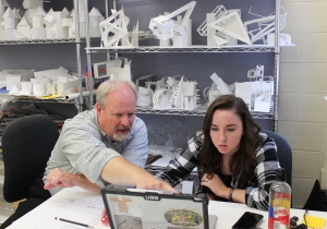 Alex Poorman works with a student