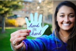 A student shares her blue paper hand cut-out